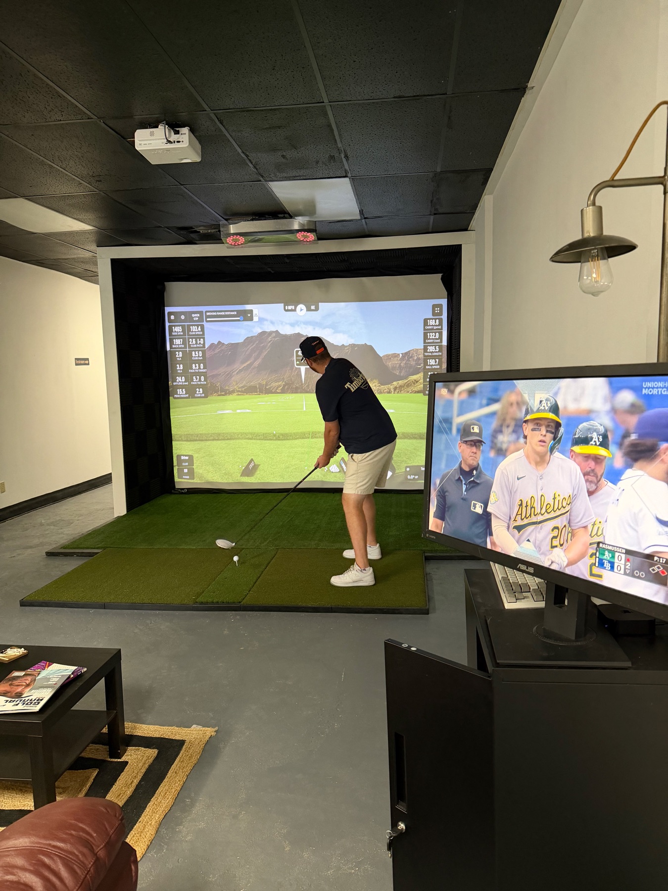 Golfer using a simulator bay at Dev's Golf Sim with the course projected on the impact screen